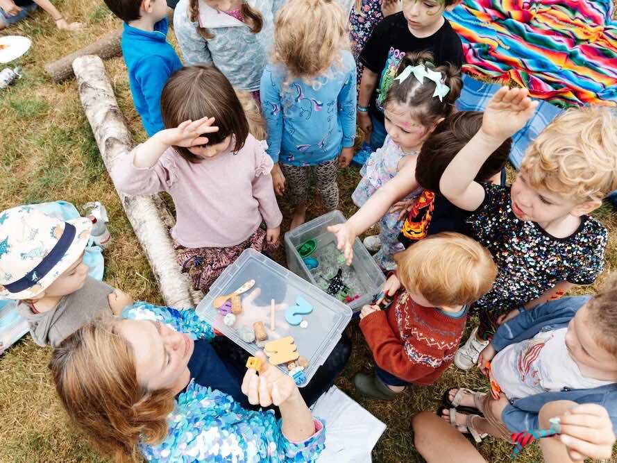 Children gathered round a craft activity at an outdoor family festival